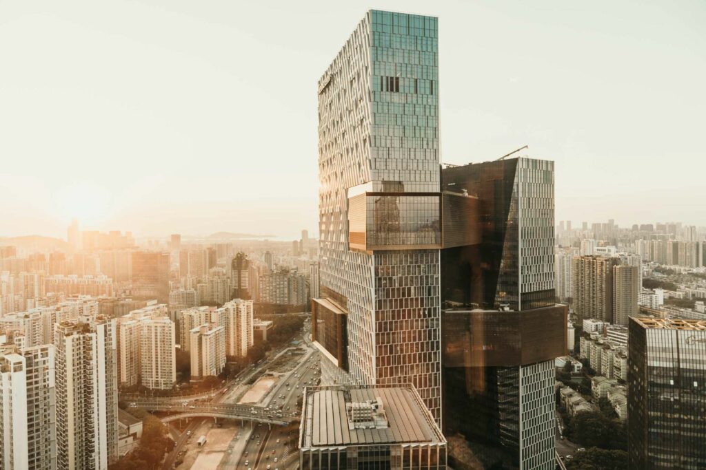 Modernes, hotelähnliches Hochhaus in Shenzhen im warmen Licht des Sonnenuntergangs – imposante Architektur, die an Premium-Hotels erinnert und starke Atmosphäre für hochwertige Hotel-Fotografie vermittelt.