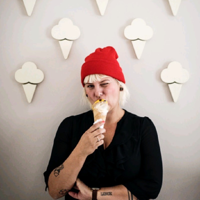 Malte-Jaeger Business und Werbefotograf Portrait von Jessika Jäger, Producerin, isst ein Eis, trägt rote Mütze – authentisches Lifestyle-Werbefoto.