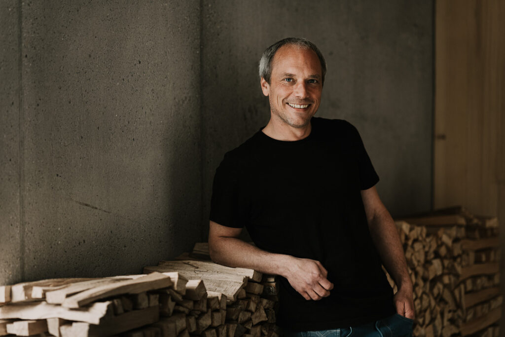 Professionelles Businessportrait eines Architekten, der selbstbewusst und sympathisch in seiner Arbeitsumgebung dargestellt wird – hochwertige Businessfotografie für Corporate Kommunikation und Unternehmenspräsentation.