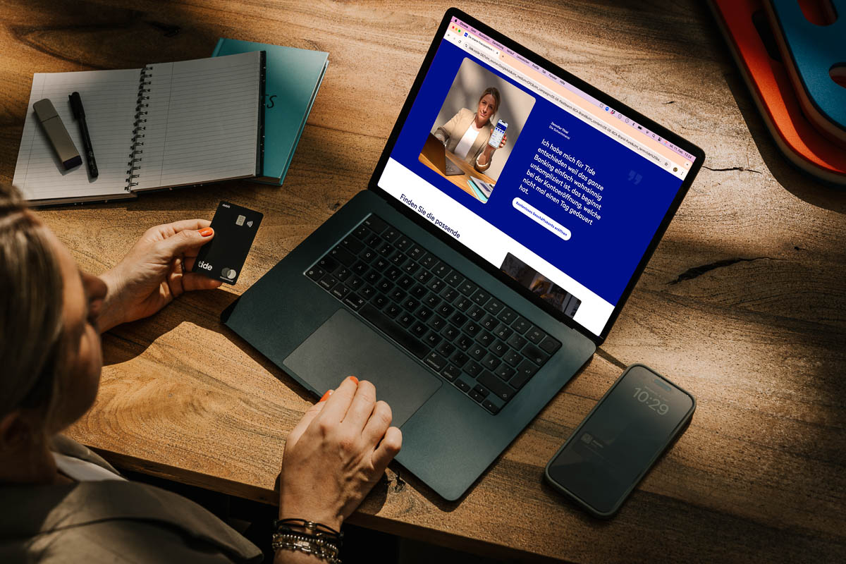 Businessfotograf und Werbefotograf inszenieren Werbekampagne mit Schwimmlehrerin beim Onlinebanking mit der Tide Karte am Beckenrand