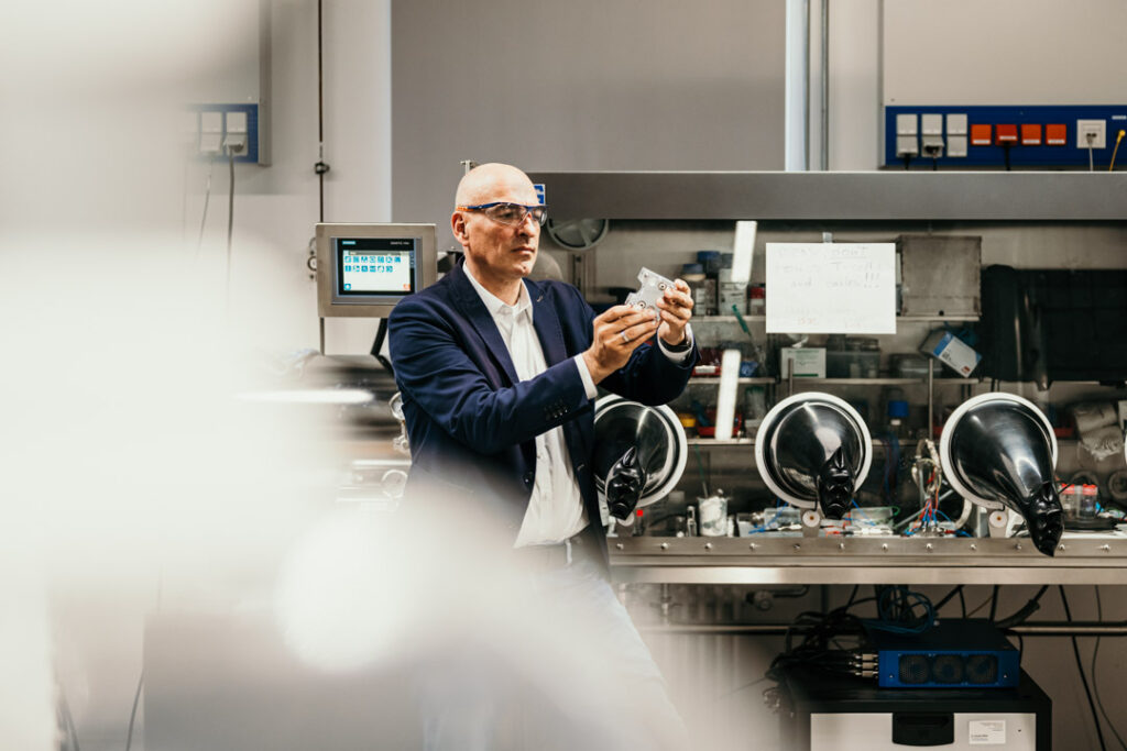 Businessportrait von Prof. Dr. S. Schubert an der FSU Jena im Labor vor einem Gerät für Batterieforschung