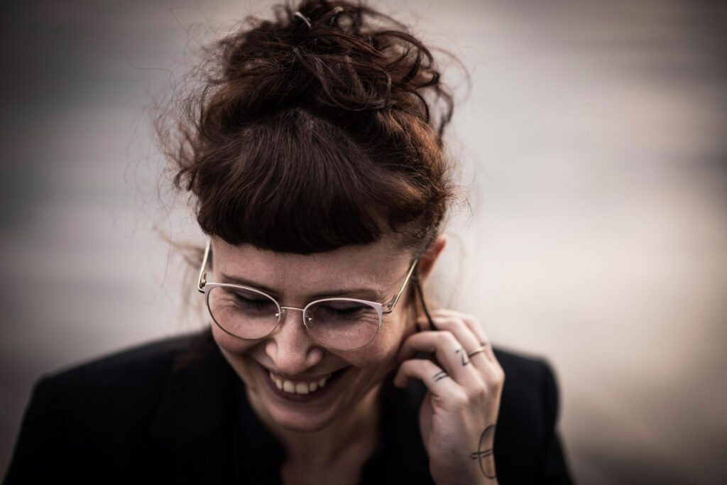 Lebendiges Businessportrait einer jungen Geschäftsfrau, die herzlich lacht – businessfotograf.