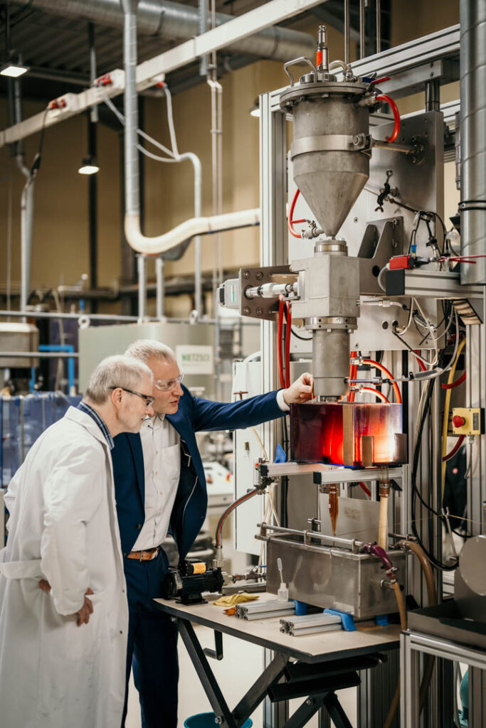 Prof. Benjamin Redlingshöfer zeigt den Versuchsaufbau im Technikum des TITK Rudolstadt seinen Kollegen, Textil- und Unternehmensfotografie
