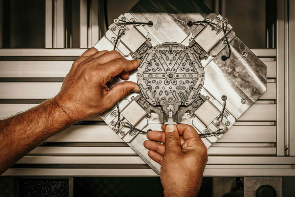 Werksreportage der Fertigung von Duschen bei Hansgrohe. Hier: Modell Raindance Alive wird zusammengebaut in Fertigungshalle., Close Up Hände, fotografiert von professionellem Businessfotograf.