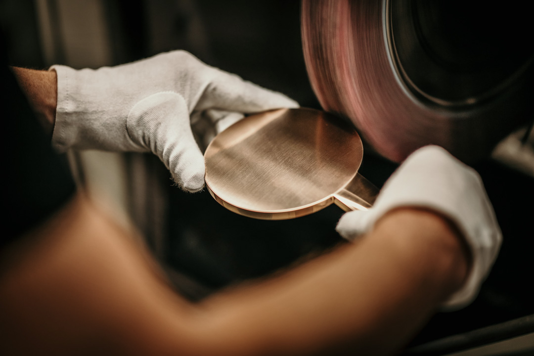 Detailaufnahme der hochwertigen Handwerksarbeit in der Produktion von Premium-Duschsystemen. Werbefotografie zeigt dunkelhaarige Frau genießt eine Dusche unter einer Hansgrohe-Dusche in einem roten Design-Badezimmer – Werbefoto mit Blick auf Rücken und Gesicht, stilvolle Bad- und Lifestyle-Inszenierung von Werbefotograf-Berlin