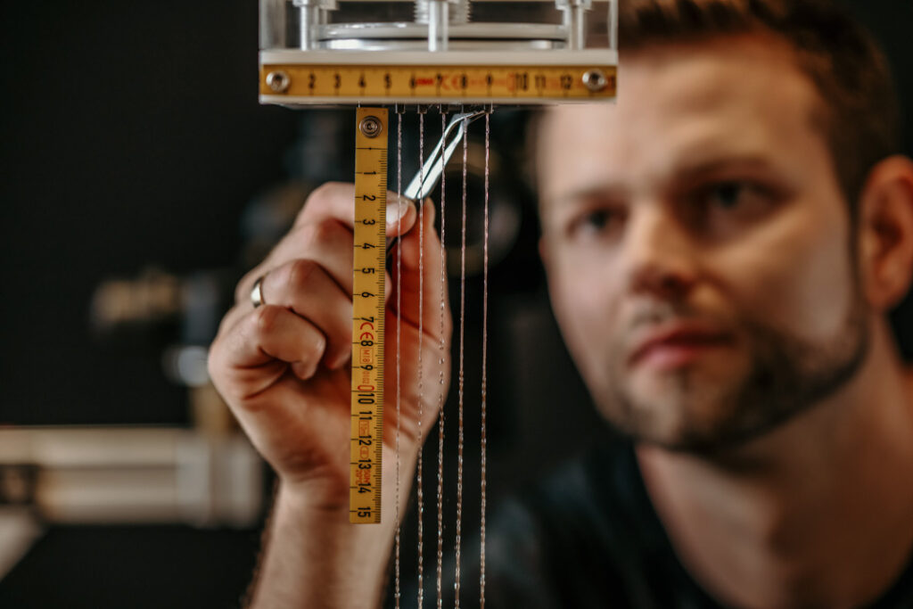 Mitarbeiter in der Hansgrohe-Testabteilung misst präzise die Größe und Performance des Duschstrahls zur Produktoptimierung, unternehmensreportage