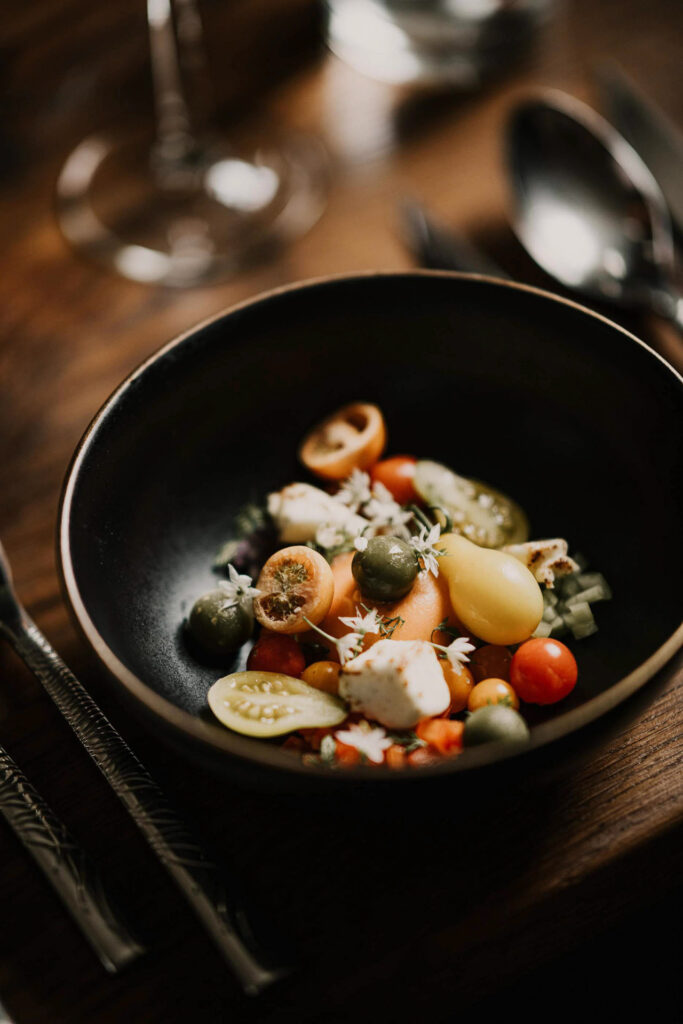 Food Fotografie Hamburg zeigt den Hirtensalat aus Spreewald-Feta, Schafgarbe und Tomaten im Restaurant Schloss Beuchow im Spreewald, kreiert von Headchef Jörg Thiele.