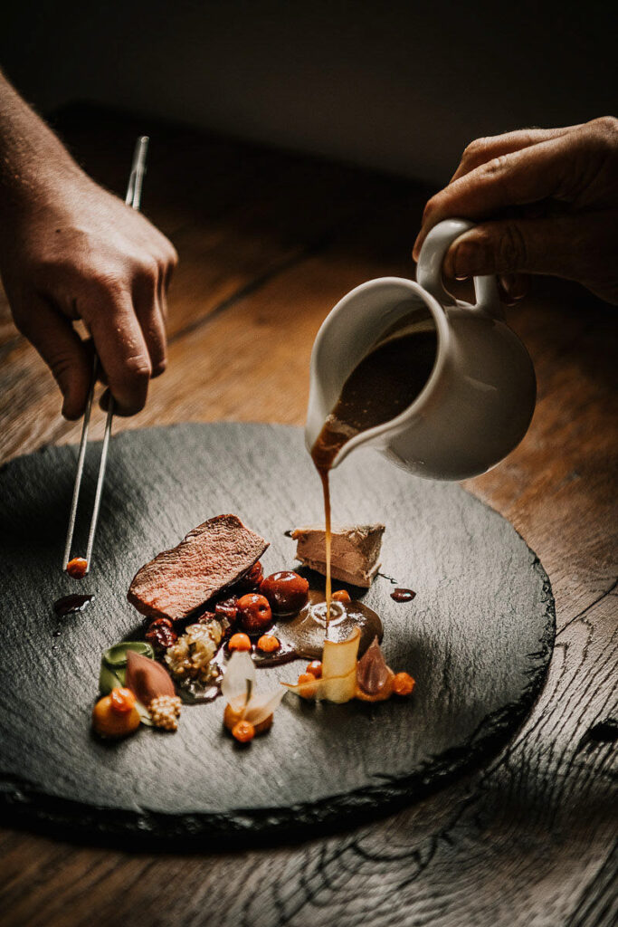 Soße wird von einem Koch über ein Wagyu-Rind-Filet gegossen – stilvolles Michelin-Star-Food-Fotografie-Motiv mit Fokus auf Gourmet-Genuss und hochwertige Restaurant-Visuals. Marketing für Restaurants