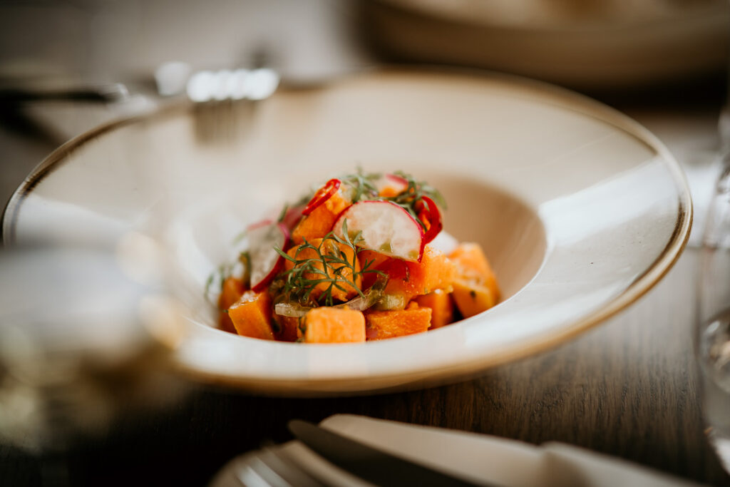Kürbisgericht auf elegant angerichtetem Teller im Food-Close-up – atmosphärische Foodfotografie für hochwertige Gastronomiepräsentationen.