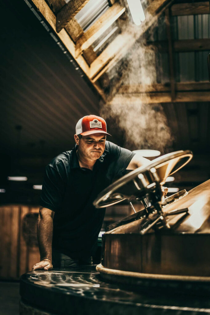 Foodfotograf Berlin zeigt den Inhaber Jeremy Norris in der Broadslab Distillery in Johnston County, North Carolina, USA, wie er seinen Moonshine-Whiskey in der Produktion verkostet.