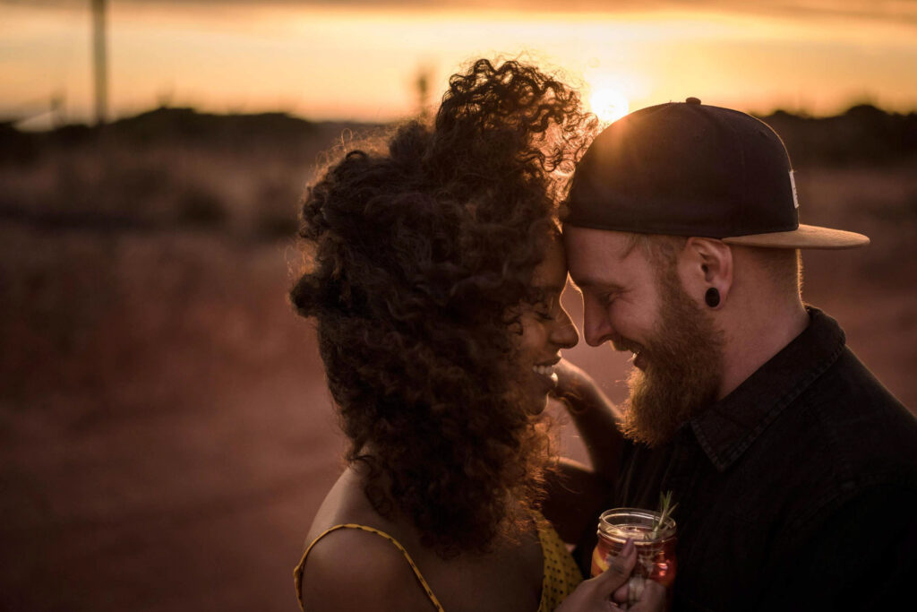 Foodfotograf Berlin zeigt ein Paar – Afrikanerin und deutscher Mann – Stirn an Stirn im Sonnenuntergang, liebevoll und intim inszeniert.