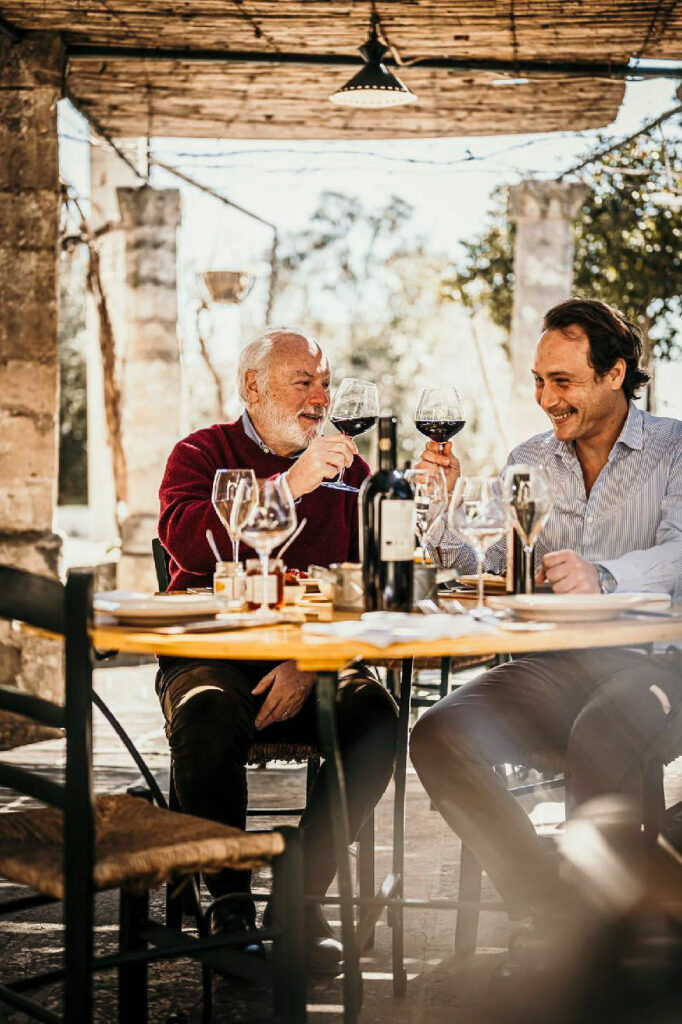 Restaurant Marketing Instagram zeigt Vater und Sohn, Besitzer des Weinguts Duca Carlo Guarini, die an einem Tisch ihres Restaurants anstoßen – authentischer Genuss und familiäre Weinkultur.