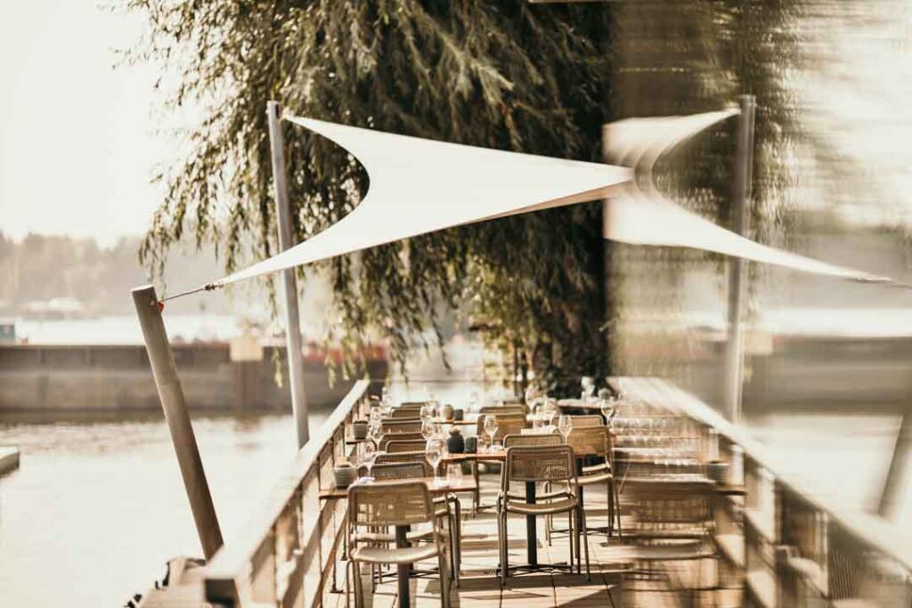 Bestuhlte Terrasse der Hafenküche direkt an der Spree – atmosphärisches Setting für hochwertige Hospitality-Fotografie.