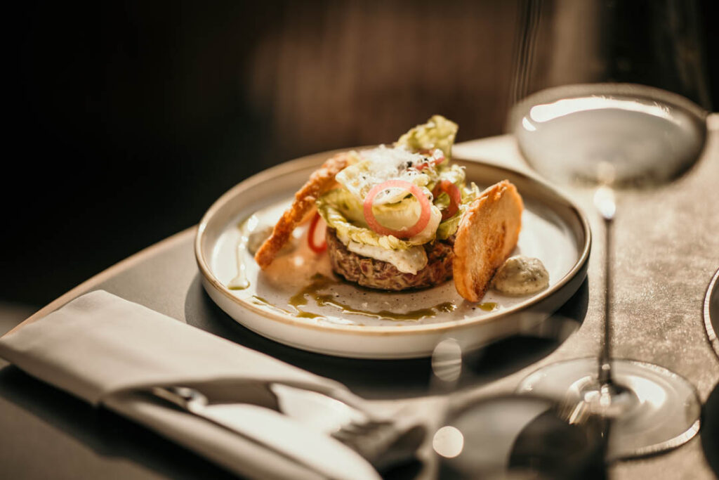 Restaurant Marketing Agency zeigt ein Beef-Tatar-Gericht mit Süßkartoffel im Restaurant Hafenküche in Berlin – kunstvoll angerichtet und authentisch für hochwertige Food-Präsentation.