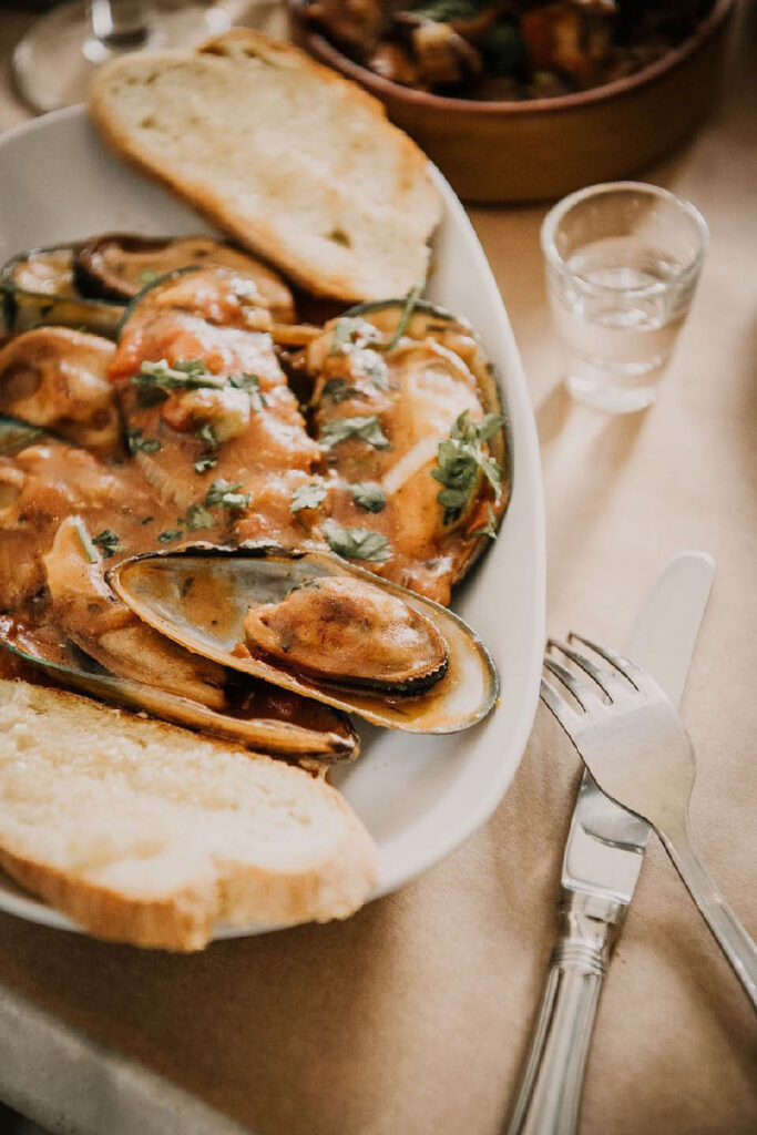 Branding Restaurants zeigt ein Scheidenmuschelgericht im Michelin-Sterne-Restaurant Sühring in Bangkok – kunstvoll angerichtet und stilvoll präsentiert.