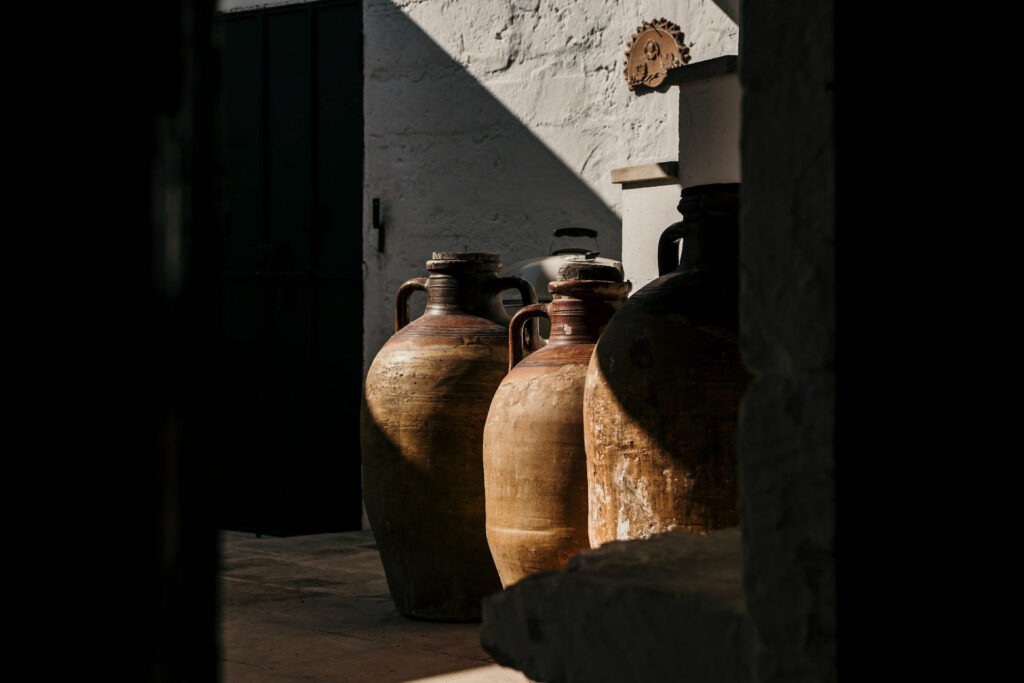 Marketing für Hotelerie zeigt Tonkrüge zur Aufbewahrung im Weingut Santo Wines auf Santorini – traditionelle Weinlagerung im Hotel- und Gastronomiekontext.