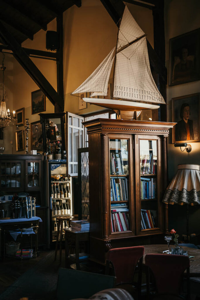 Food Fotograf München zeigt ein Interieur-Detail mit Modellsegelboot im Restaurant Strandhalle in Binz auf Rügen, Mecklenburg-Vorpommern – stilvolle und maritime Restaurant-Atmosphäre.