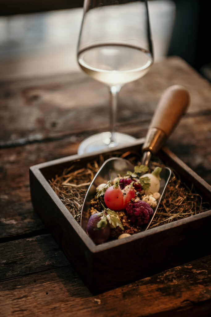 Restaurant Marketing Instagram zeigt ein Amuse-Gouche mit Blumenkohl, Radieschen auf falscher Erde, Liebstöckel und Muschel-Crunch im Michelin-Sterne-Restaurant Freustil in Binz auf Rügen – kunstvoll angerichtet von Chef Ralf Haug.