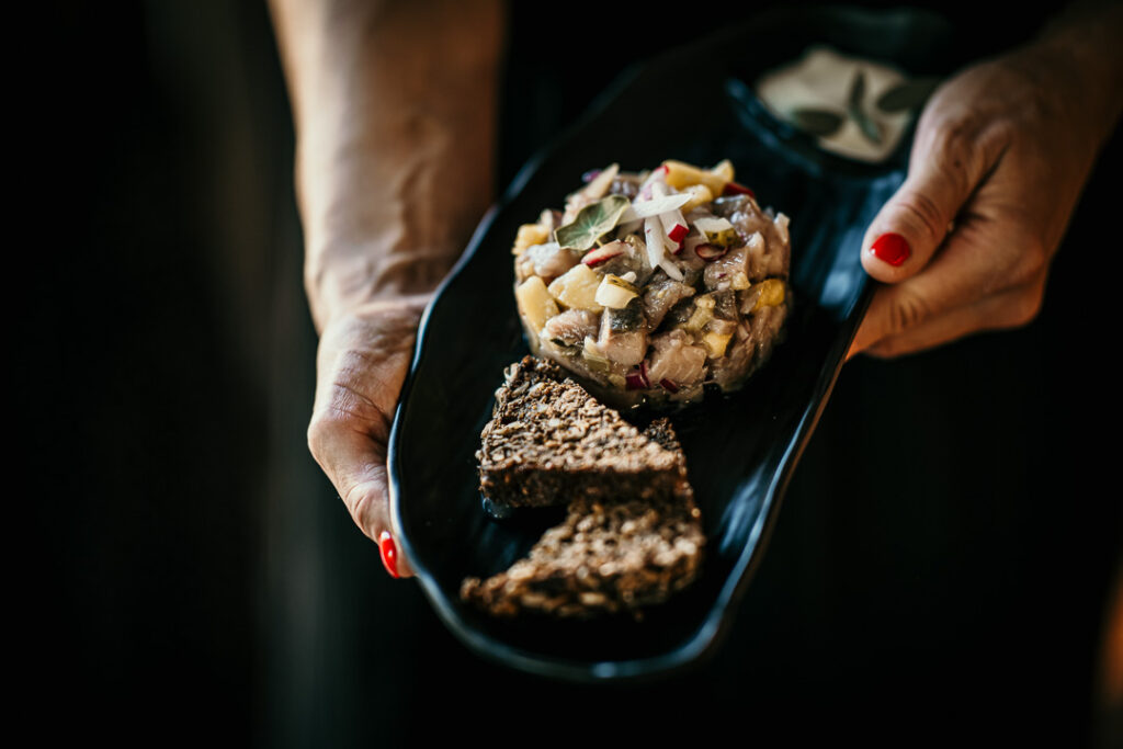 Restaurant Marketing Agency zeigt Matjes-Tartar im Restaurant Küste und Wiese auf Mönchgut, Rügen, Mecklenburg-Vorpommern – kunstvoll angerichtet von Chef Katja Klatt.