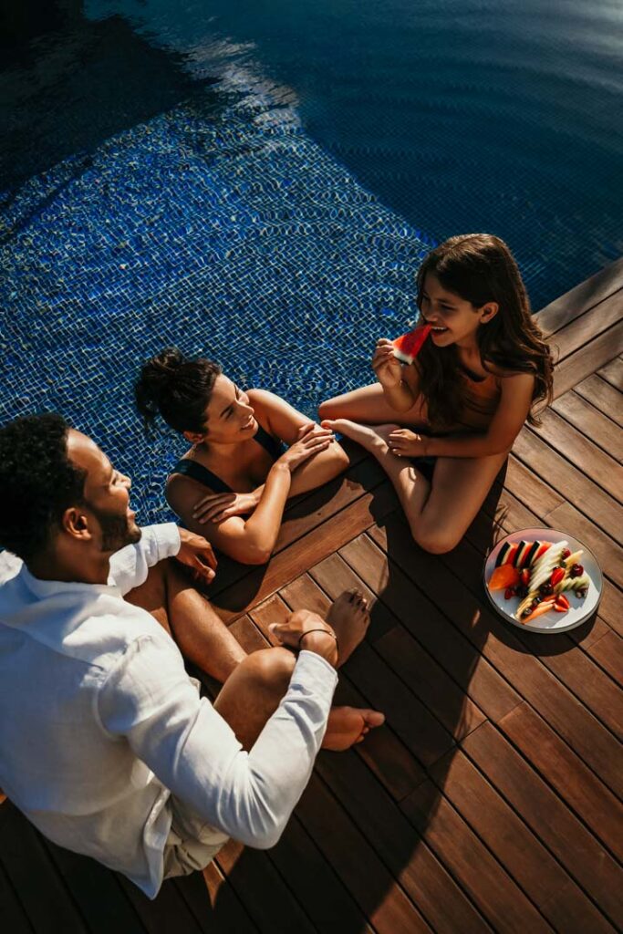 Mutter, Vater und Kind genießen gemeinsam Obst am Rand des Sofitel-Pools – stimmungsvolles Hotelfoto für Hospitality-Marketing