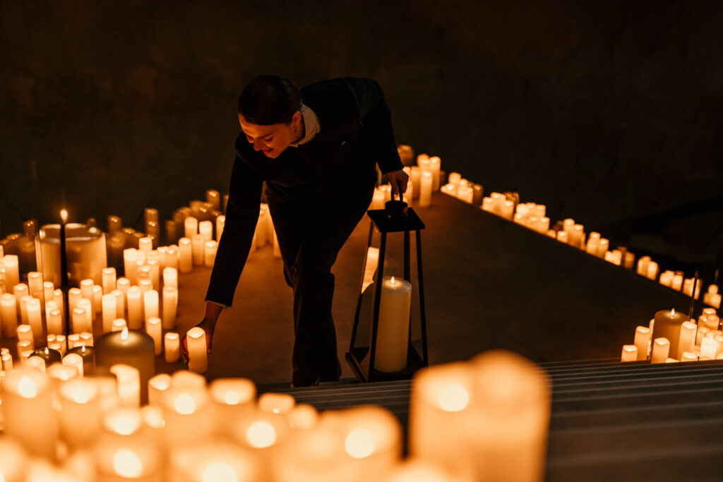 Hotelmitarbeiterin (Concierge) zündet abends Kerzen auf der Treppe im Sofitel Hotel an – stimmungsvolles Hotelfoto für Hospitality-Marketing