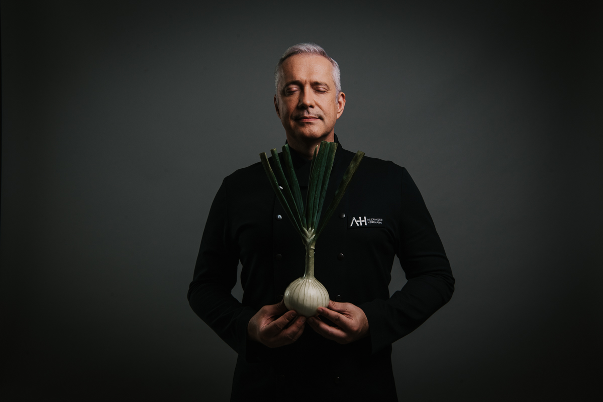 Fernsehkoch Alexander Herrmann Portrait mit Zwiebel – fotografiert von Werbefotograf und Foodfotograf Berlin.