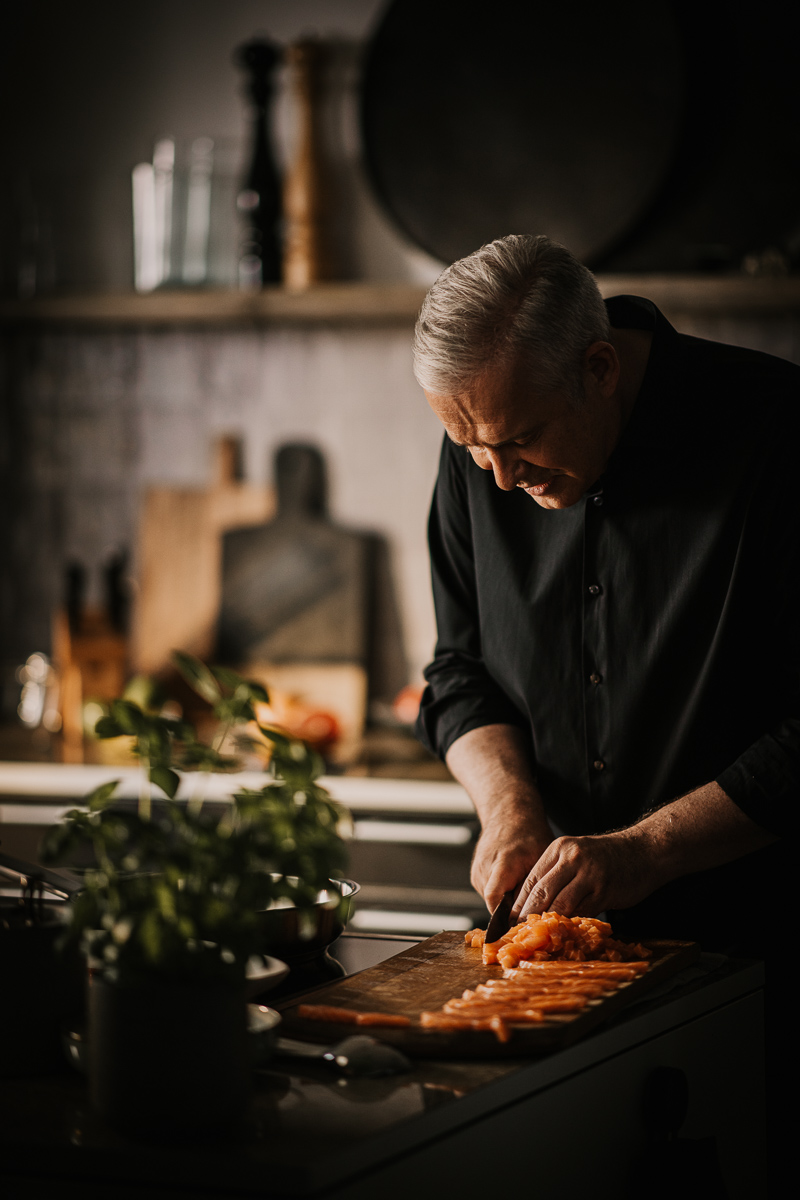 Professionelles Portrait von Fernsehkoch Alexander Herrmann mit Lachs, aufgenommen von einem erfahrenen Werbefotograf und Foodfotograf Berlin. Hochwertige, authentische Darstellung für kulinarische Marken, Magazine und Kampagnen – Fokus auf natürlicher Lichtstimmung und charakterstarkem Ausdruck.
