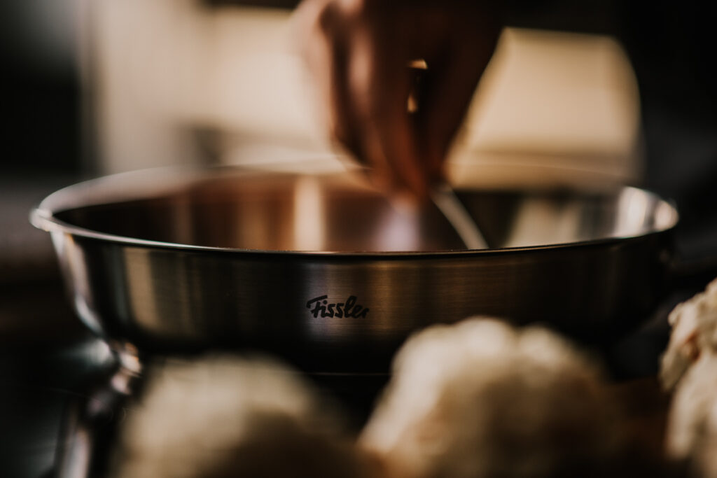 Fissler-Pfanne im Einsatz beim Kochen, dynamisches Food-Close-up professionell eingefangen von einem erfahrenen Foodfotografen.