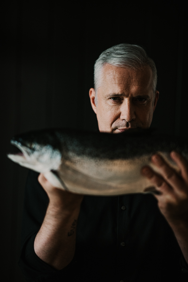 Fernsehkoch Alexander Herrmann Portrait mit einem Stück Lachs – fotografiert von Werbefotograf und Foodfotograf Berlin.