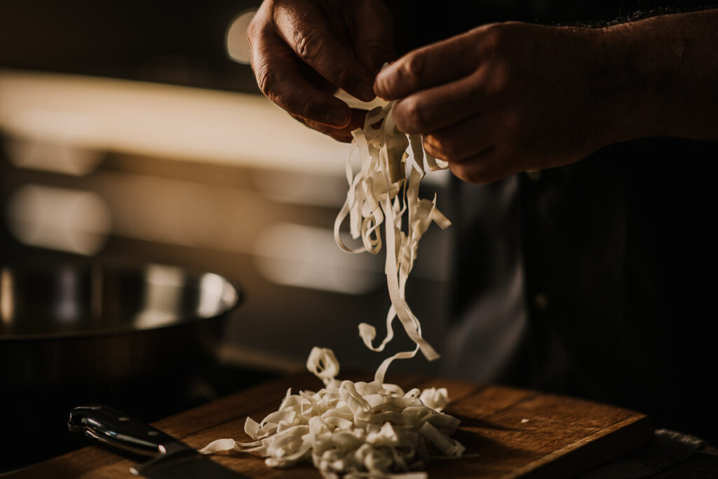 Detail-Close-up der Hände von Fernsehkoch Alexander Herrmann beim Kochen, präzise Bewegung und hochwertige Zutaten, inszeniert von einem erfahrenen foodfotograf für eine Werbekampagne von Fissler.