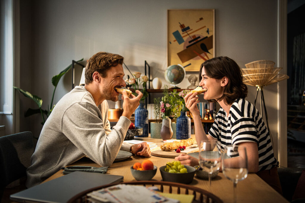 Französisches Lebensgefühl: Paar probiert Käse, entspanntes Essen und Freude sichtbar, aufgenommen von Werbefotografin Berlin.