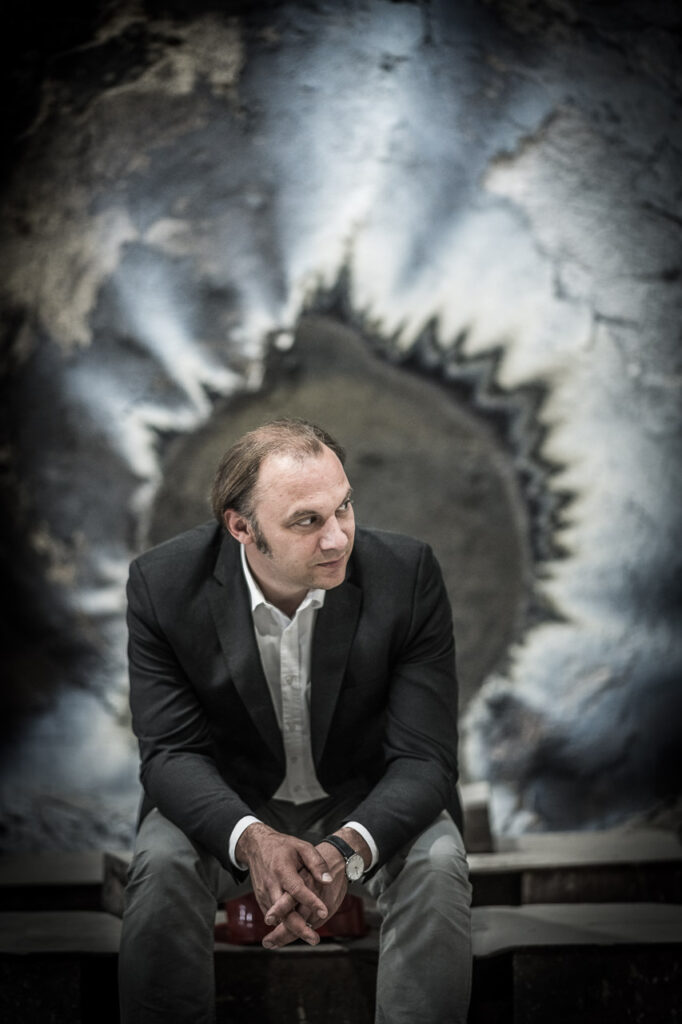 Businessportrait von Dr. Lars Greitsch, CEO der MMG, vor verbrannten Metallplatten in der Werkshalle in Waren an der Müritz, Unternehmensfotografie