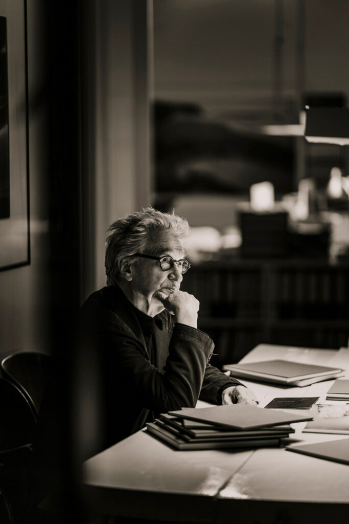 Regisseur Wim Wenders sitzt am Schreibtisch – Schwarz-Weiß Businessportrait von Businessfotograf Hamburg