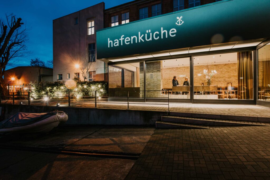 Außenansicht des Restaurants Hafenküche Berlin bei Nacht, stimmungsvolle Atmosphäre authentisch eingefangen in hochwertiger Hospitality-Fotografie für modernes Hotel- und Gastro-Marketing.
