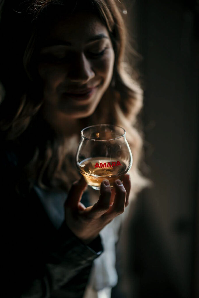 Foodfotograf Hamburg zeigt eine Frau, die den Geruch von Amargo Amara Likör genießt – Werbefoto im Detail.