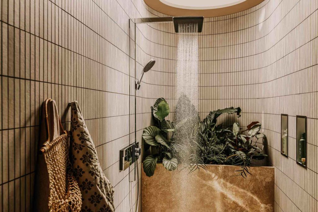 Wasser läuft aus einer Hansgrohe-Design-Kopfbrause in einer modernen Dusche mit integrierten Pflanzen – stilvolle Bad- und Lifestyle-Inszenierung von Werbefotograf aus Berlin.