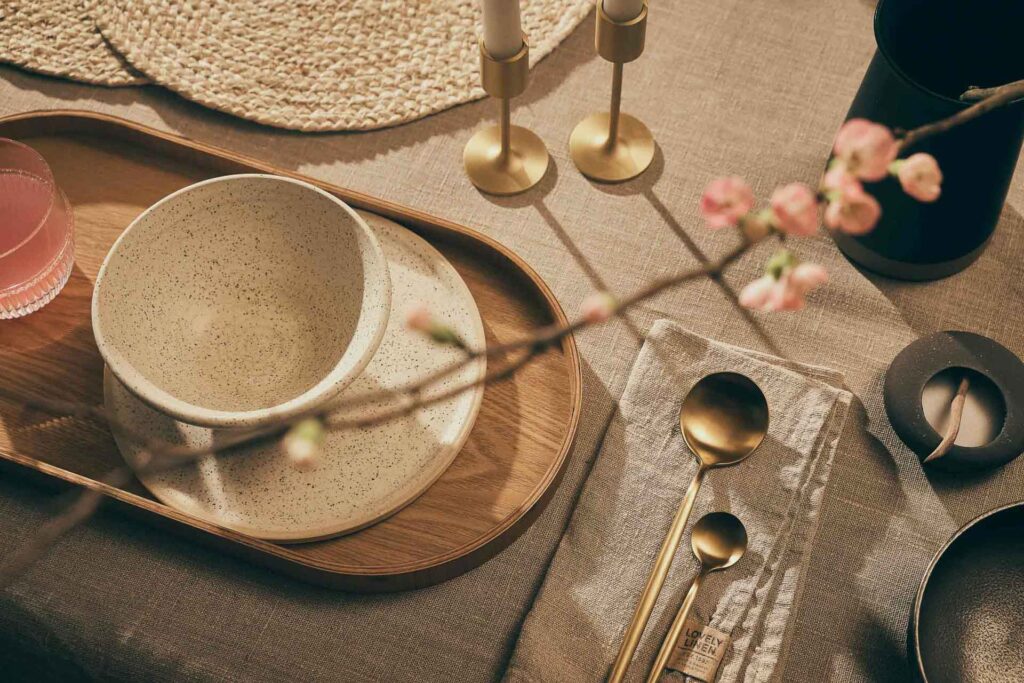 Interieur-Aufnahme eines stilvoll gedeckten Tisches mit Tellern, Löffeln und Wohnaccessoires – authentisch inszeniert von Werbefotograf Berlin