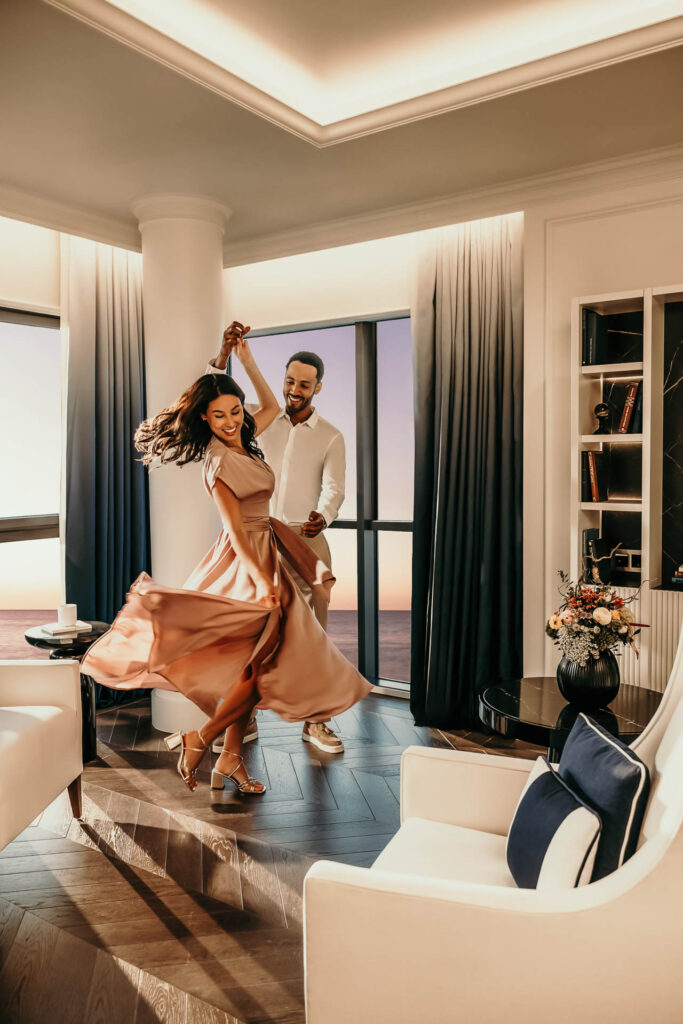 Tanzendes Paar vor Meerblick im französischen Zimmer des Sofitel Barcelona – Hotelfotograf aus Berlin erstellt Lifestyle-Werbefoto und Businessfoto
