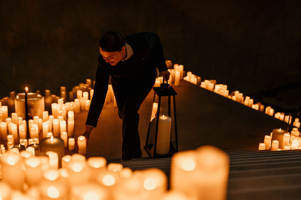 Hotelmitarbeiterin (Concierge) zündet abends Kerzen auf der Treppe im Sofitel Hotel an – stimmungsvolles Hotelfoto für Hospitality-Marketing
