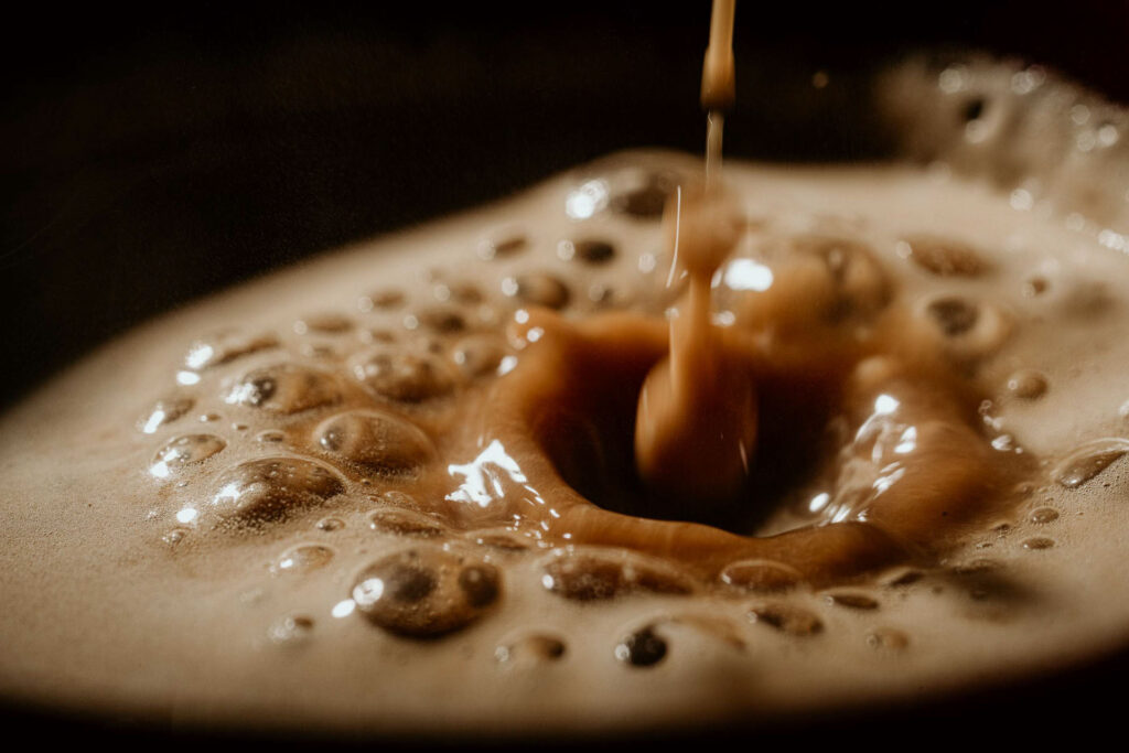 Food Fotograf zeigt ein extrem Close-up von frischem Nespresso, der aus der Maschine läuft.