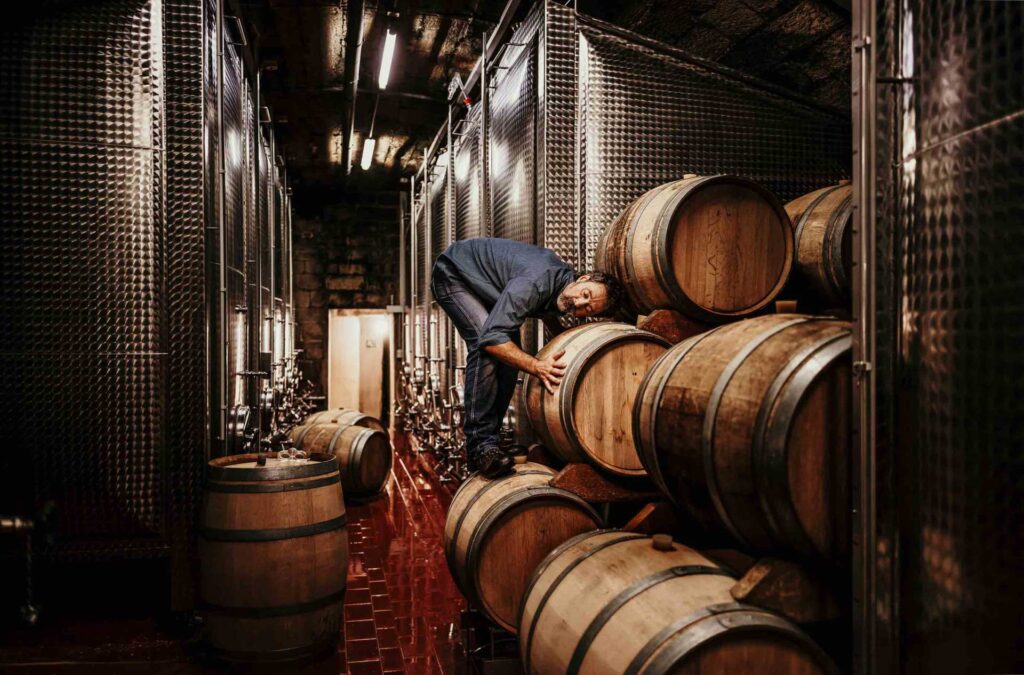 Foodfotograf zeigt einen Kellermeister, der den Wein im Fass in seinem Weinkeller prüft – Werbekampagne für das Deutsche Weininstitut über alle deutschen Weinanbaugebiete.