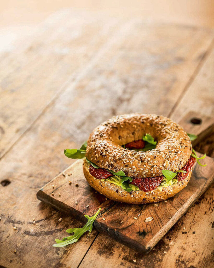 Foodfotograf Hamburg präsentiert einen Bagel mit getrockneten Tomaten – Werbefotografie für BackWerk.