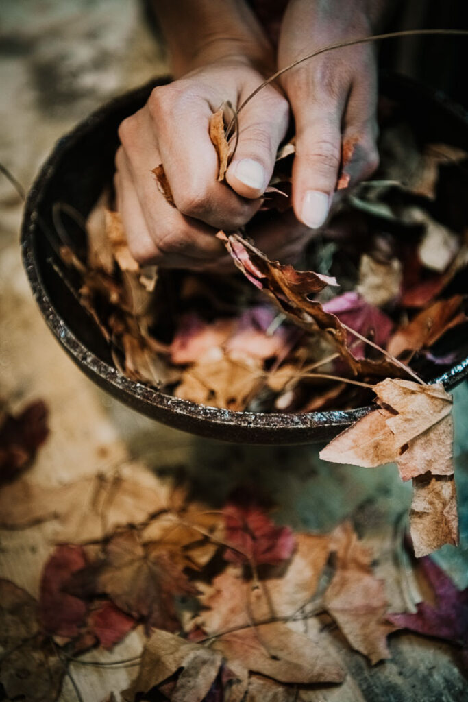 Close-up von Jasmin Castagneros Händen, die Blätter im Mörser für die Lampenherstellung in ihrer Manufaktur zerkleinern, Miyuca