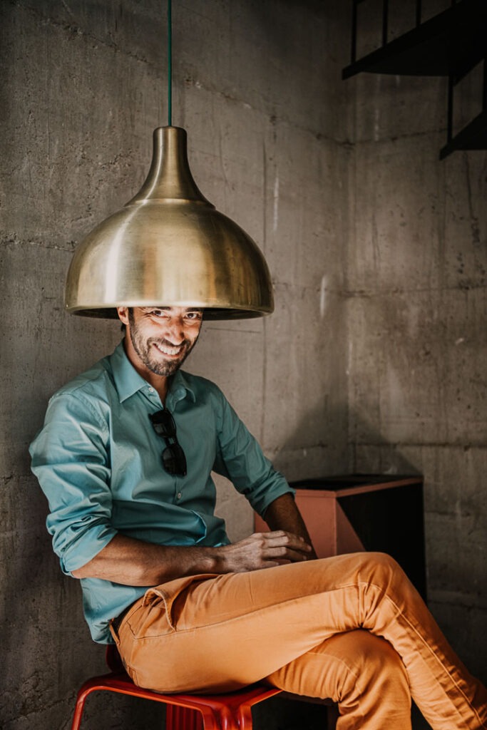 Businessportrait von Produktdesigner Harry Thaler in Meran, Südtirol, der nach vielen Jahren Arbeit in London sein Studio in Italien betreibt, mit selbst designter Lampe.