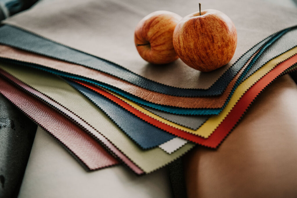 Apfelleder und frische Äpfel als Produktbeispiele von Frumat, dem Start-up von Hannes Parth in Bozen, Südtirol, das veganes Leder und Papier aus Apfelresten herstellt