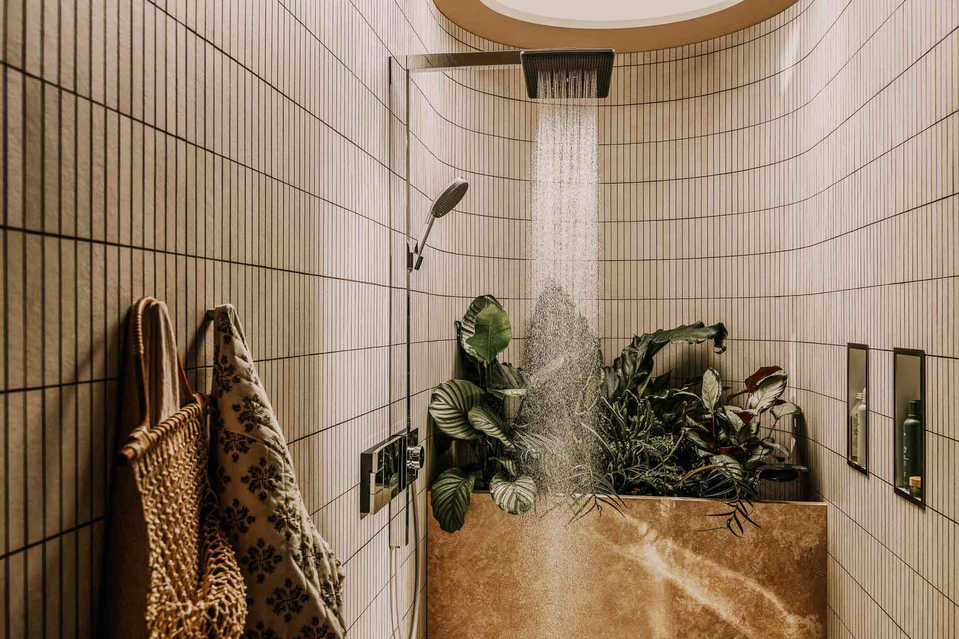 Businessfotograf Magdeburg: Wasser läuft aus Hansgrohe Kopfbrause in modernem Badezimmer mit Pflanzen – hochwertige Businessfotografie und stilvolle Lifestyle-Inszenierung für Markenkommunikation.