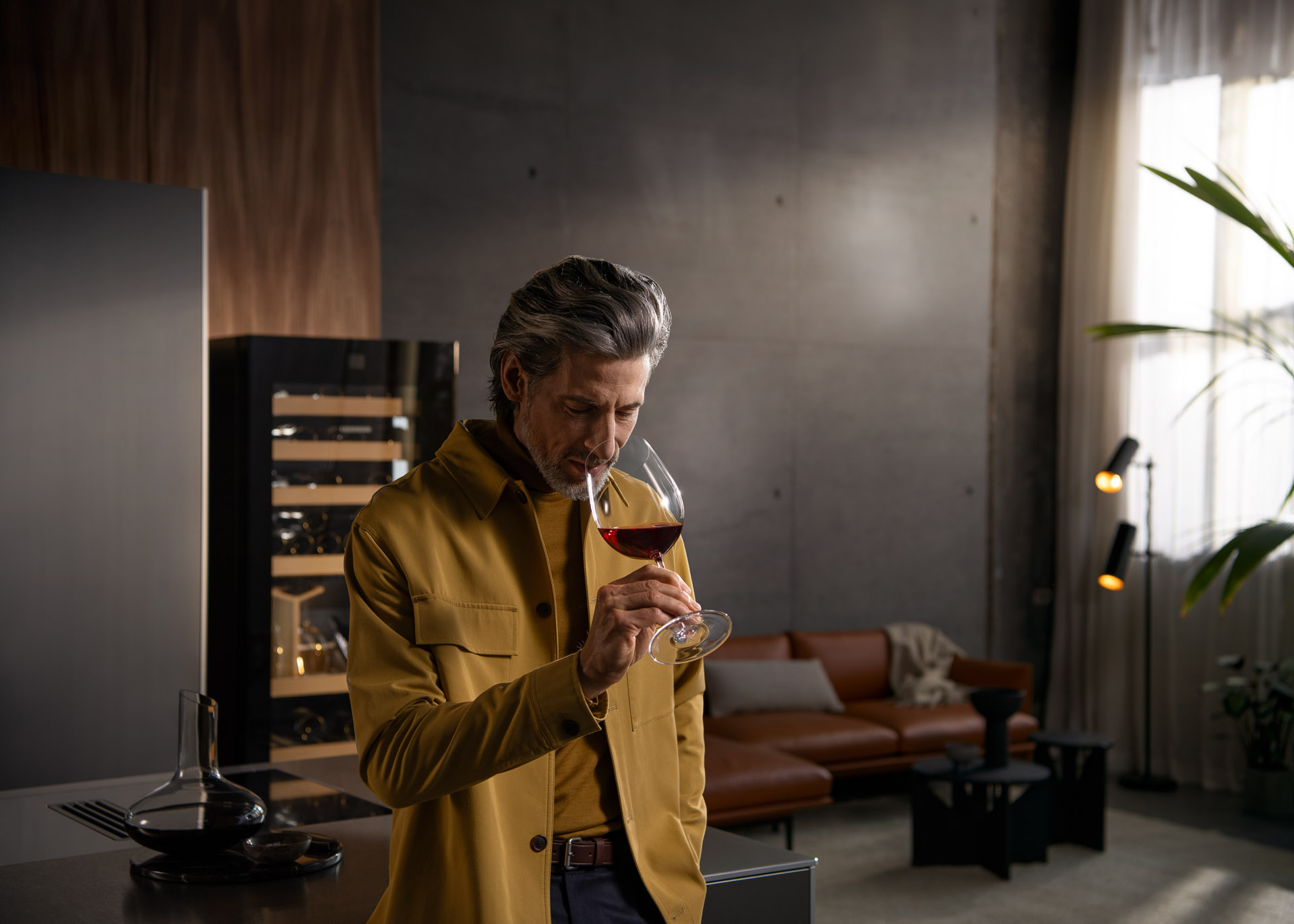 Werbefotografie Hamburg: Genussmoment eines Best Agers in moderner Küche mit Liebherr Vinidor – emotionale Werbefotografie für Premium-Markenkommunikation und Lifestyle-Marketing.