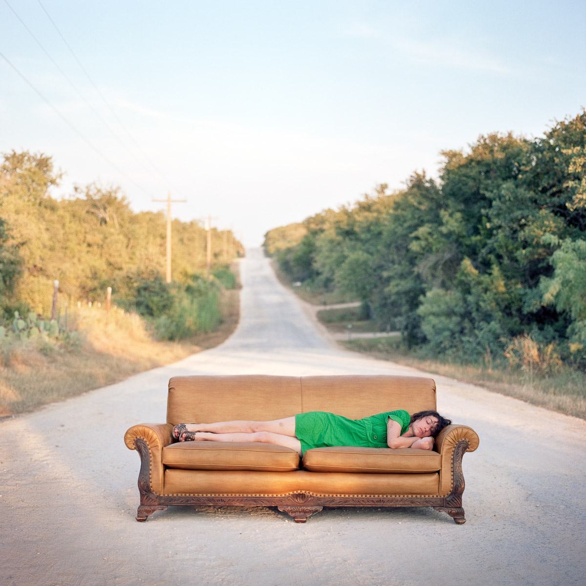 Magazinfotograf zeigt ein Sofa auf leerer Straße als surrealen Moment einer Couchsurfing Reportage - dokumentarfotografie über Reisen, Begegnung und temporäres Zuhause