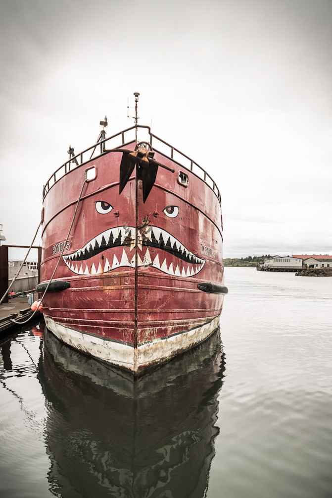 Fischerboot mit gemaltem Hai-Gesicht im Hafen, dokumentarische Fotografie aus der Fisherpoets-Community an der US-Westküste Keywords: fishermen photography, fishing boat portrait, documentary photography harbor, fisherpoets project, west coast fishing culture